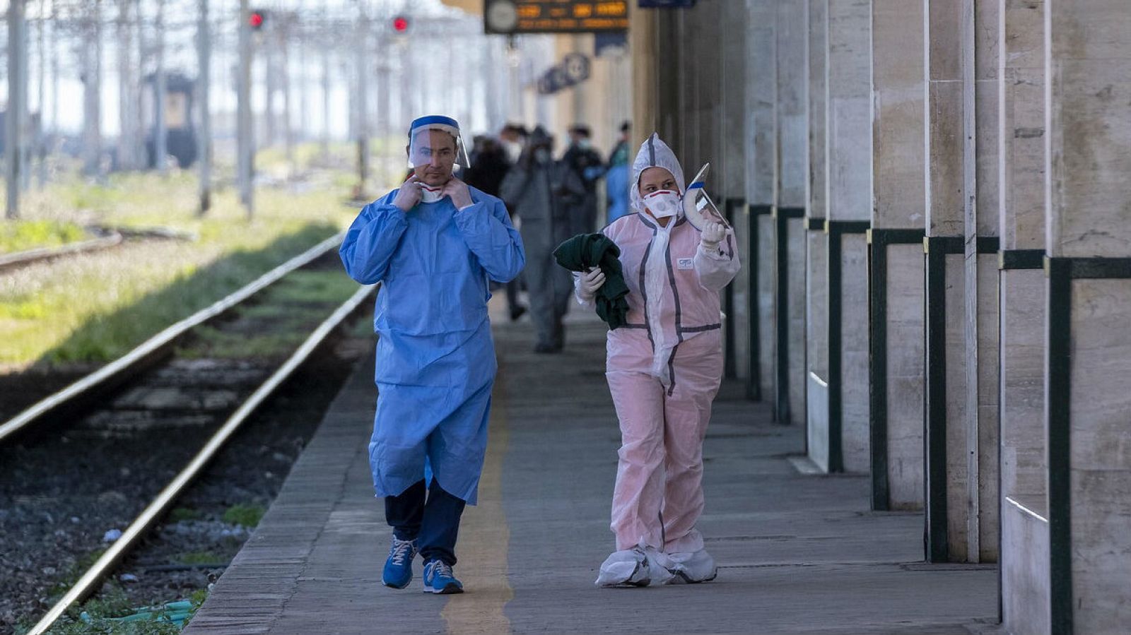 Personnel d'une gare en Italie avec des combinaisons spÃ©ciales pour se protÃ©ger contre le coronavirus.