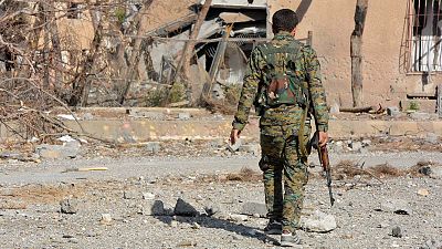 Un combatiente de las Fuerzas Democráticas Sirias en medio de las ruinas de Al Raqa