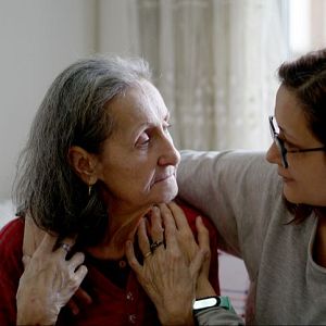 Cuaderno mayor - Dos mujeres, una mayor y otra joven, comparten un momento de apoyo y consuelo en un ambiente hogareño. La mujer joven consuela a la mayor, que muestra una expresión de preocupación.