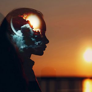 A golpe de bit - Doble exposición: silueta femenina con cielo de atardecer y elementos celestiales (sol y luna) dentro de la cabeza, simbolizando la dualidad interna y los ciclos naturales.