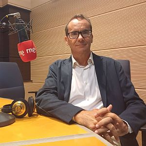 Jaquelandia - El periodista David Jiménez aparece en un estudio de radio con micrófono de espuma roja y auriculares, sobre un fondo de paneles acústicos de madera.