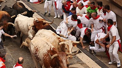 Los toros de la ganadería La Palmosilla pasan por el tramo que va desde el final de la cuesta de Santo Domingo a la curva de Mercaderes, en el primer encierro de los sanfermines 2023.
