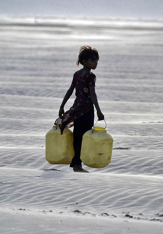 Una niña transporta garrafas vacías para recoger agua en el pueblo de Chilla, en el estado norteño de Uttar Pradesh. El Gobierno indio ha denunciado la pertinaz sequía que sufre su país y que es uno de los factores de la crisis alimentaria.