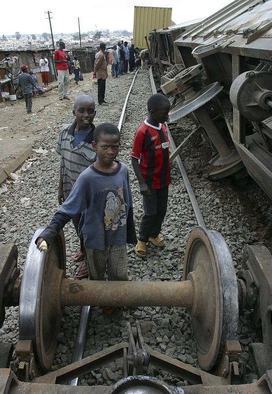Children look at wreckage of derailed freight train along the Kenya-Uganda railway line in Kibera slums