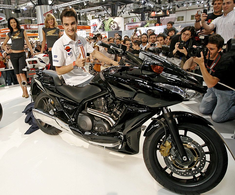El piloto de motociclismo Dani Pedrosa, actual líder de Moto GP, posa con la Honda DN-01, la principal novedad que la marca japonesa ha mostrado en la Feria MotOh!