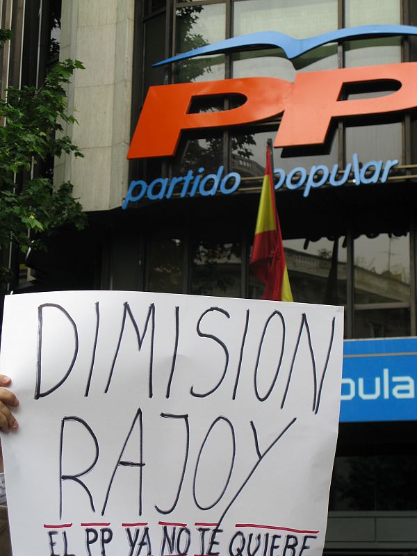 Ante la sede del PP una pancarta pide la dimisión del presidente del partido, Mariano Rajoy.