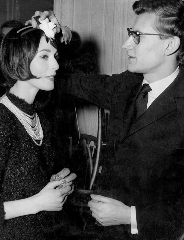 Fotografía de archivo del año 1957 del joven diseñador de moda Yves Saint Laurent colocando una flor en la cabeza de una modelo antes del desfile con la últimas creaciones de la Casa Dior.