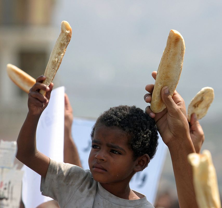 Un niño con mendrugo de pan en una manifestación en Taiz (Yemen). Mientras que los países productores de petróleo árabes siguen aumentando sus ingresos, en otras partes del mundo Árabe se lucha contra el incremento de los precios de los alimentos.