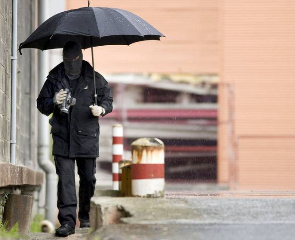 Un agente de la Ertzaintza graba en vídeo los alrededores las instalaciones de El Correo en Zamudio, donde ETA ha hecho explotar una bomba.
