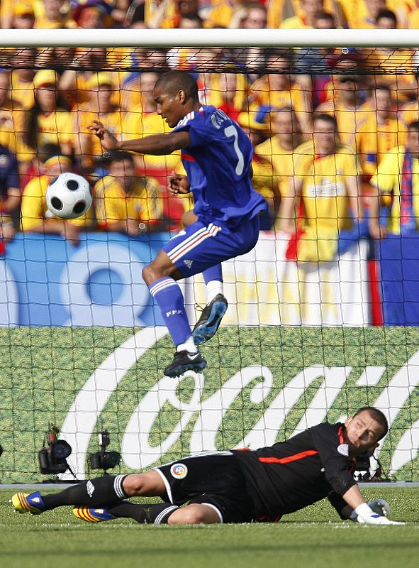 El portero de Rumanía Bogdan despeja el balón ante el extremo francés Florent Malouda.