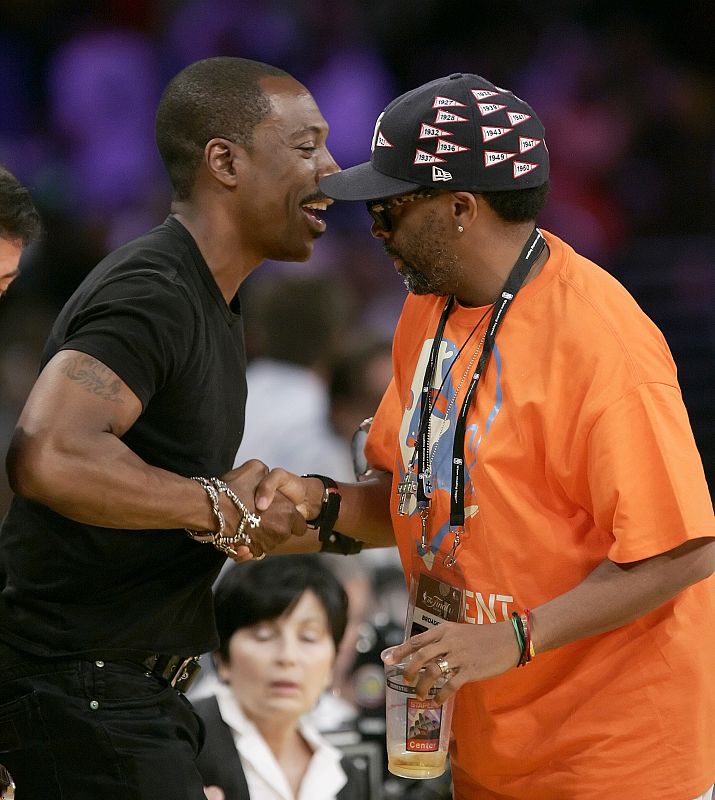 El director de cine Spike Lee y el actor Eddie Murphy charlan minutos previos al inicio del tercer partido de la final de la NBA en el estadio de los Angeles Lakers.