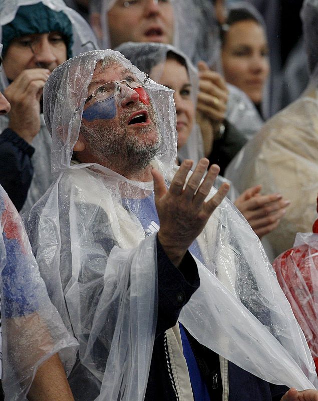 Fútbol bajo la lluvia. Un aficionado francés se protege de la lluvia con un chubasquero antes del comienzo del partido de Francia contra Italia.