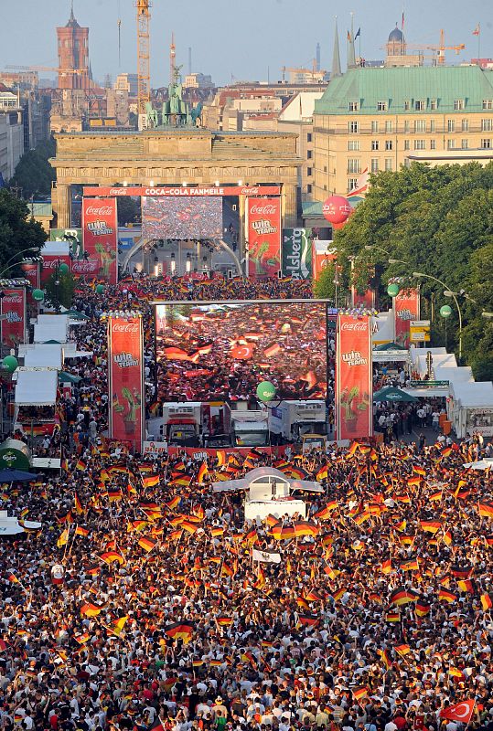 Miles de aficionados se congregan en la Puerta de Brandemburgo para seguir desde una pantalla gigante de televisión el partido de Alemania contra Turquía.