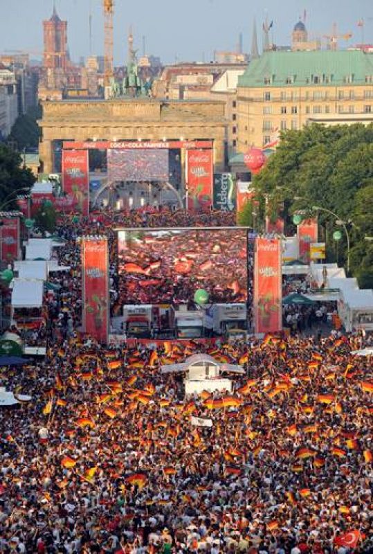 Miles de aficionados se congregan en la Puerta de Brandemburgo para seguir desde una pantalla gigante de televisión el partido de Alemania contra Turquía. 