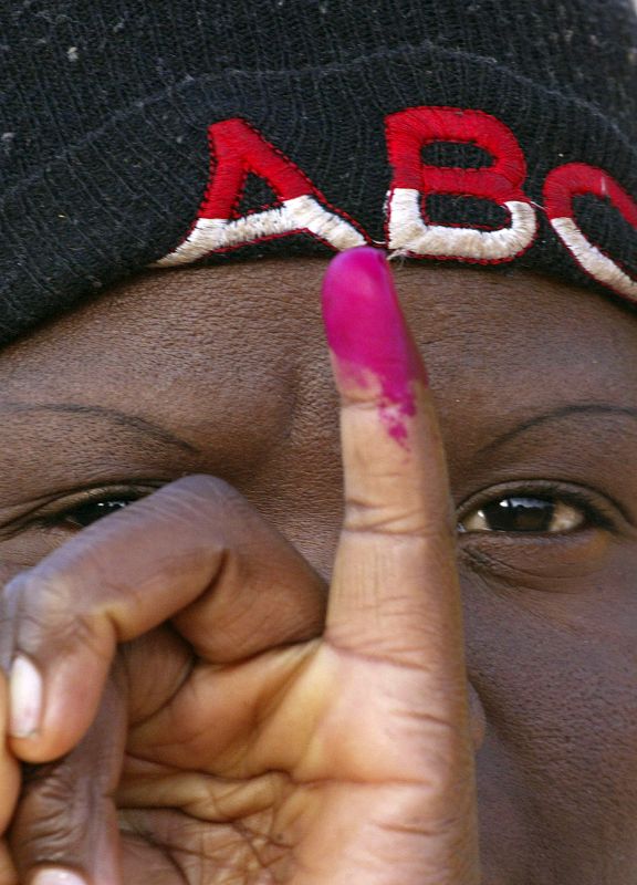 Una zimbabuense muestra a la cámara su dedo marcado después de haber votado en la segunda vuelta de unas elecciones calificadas de "farsa" por la comunidad internacional.