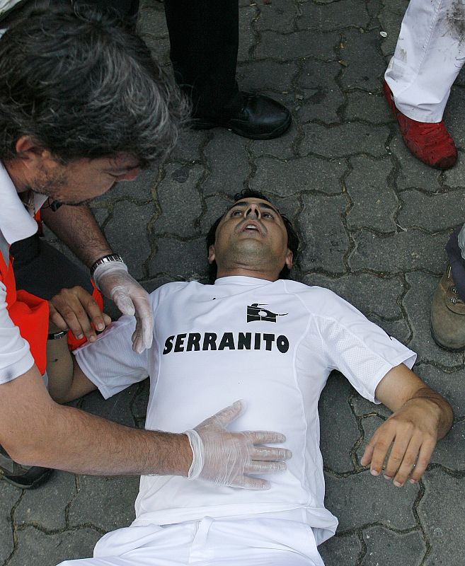 An injured runner receives medical attention after fifth day of the running of the bulls at the San Fermin festival in Pamplona