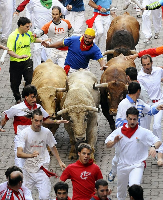 Runners are chased by Nunez del Cuvillo ranch bulls during the last bull run of the San Fermin festival in Pamplona