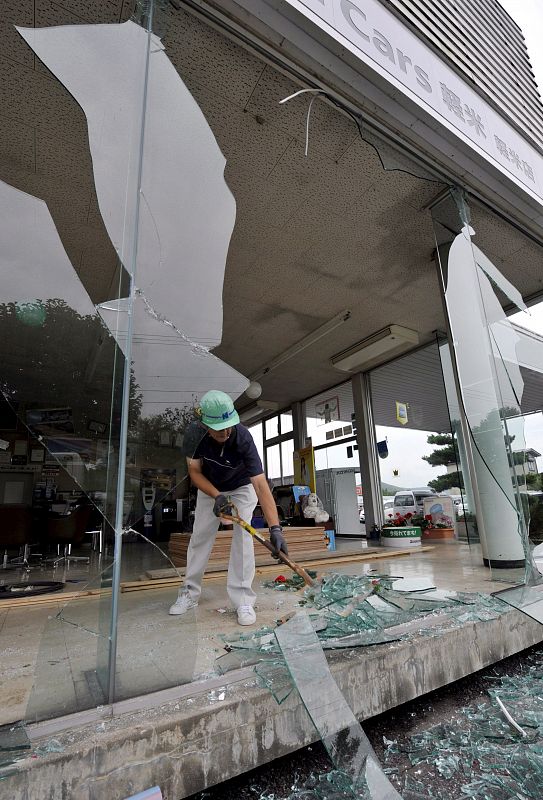 Un trabajador limpia trozos de cristales rotos tras el azote de un terremoto en Hirono, al norte de Japón, el jueves 24 de julio. El terremoto, que ha alcanzado una magnitud de 6.8 en la escala Richter, al dejado al menos 109 personas heridas.