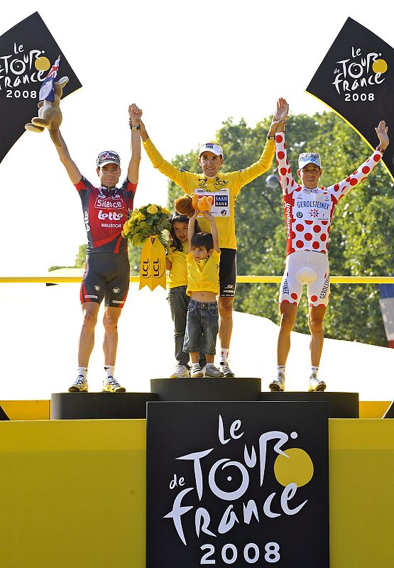 El ganador del Tour'08, Carlos Sastre, celebra sobre el podio su victoria.