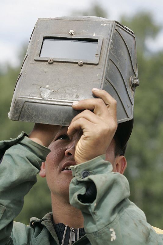 Un trabajador observa el eclipse con su máscara de soldador