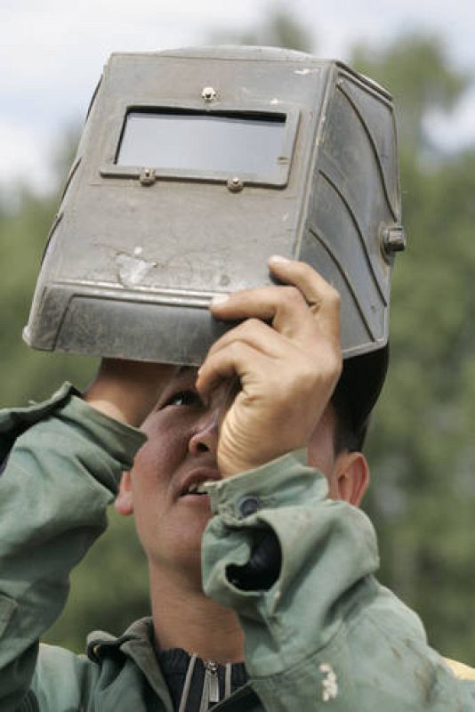 Un trabajador observa el eclipse con su máscara de soldador