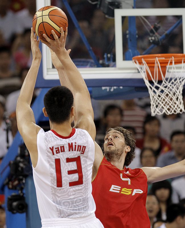 El jugador chino Yao Ming lanza la pelota ante el bloqueo del español Pau Gasol.