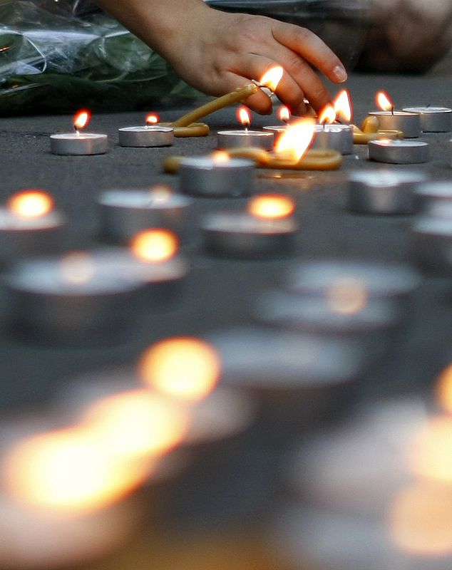 Una mujer enciende velas por las víctimas de la guerra ante la embajada rusa en Bucarest, Rumanía