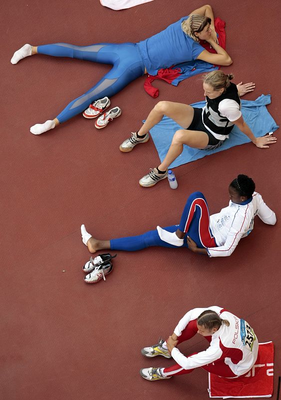 Athletes relax before competing in the women's heptathlon high jump qualifying round at the National Stadium during the Beijing 2008 Olympic Games