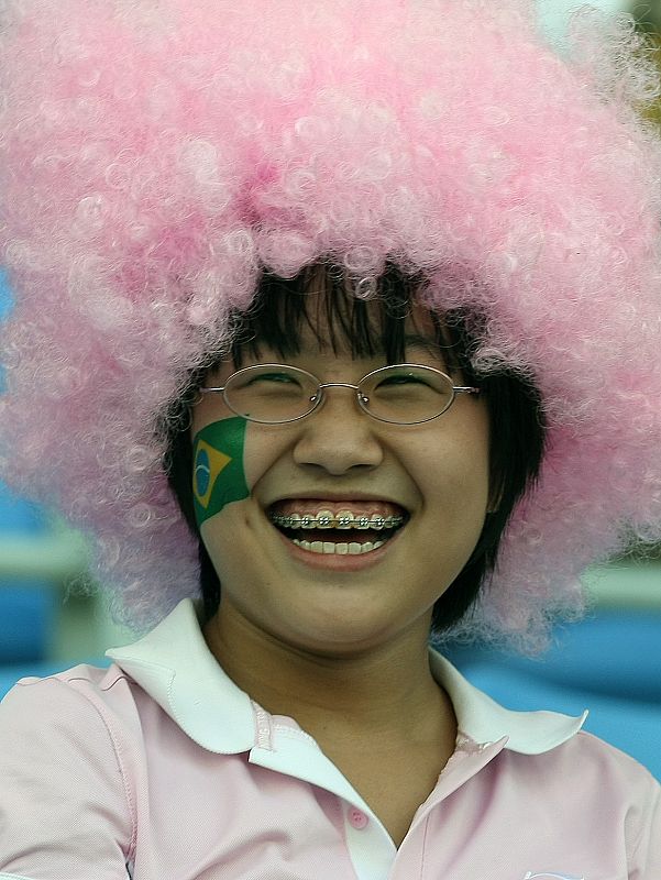 Una aficionada china se divierte mientras espera el inicio del partido de cuartos de final de los Juegos Olímpicos de Pekín entre Brasil y Camerún.