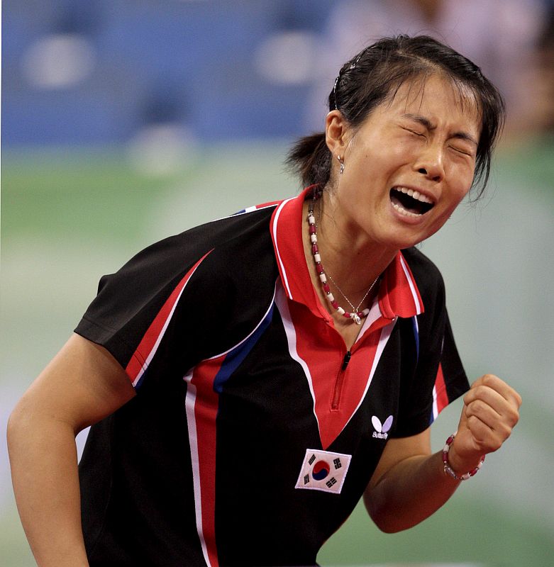 La surcoreana Kim Kyung Ah celebra su victoria ante la japonesa Sayaka Hirano durante la lucha por la medalla de bronce en la segunda ronda de tenis de mesa femenino.