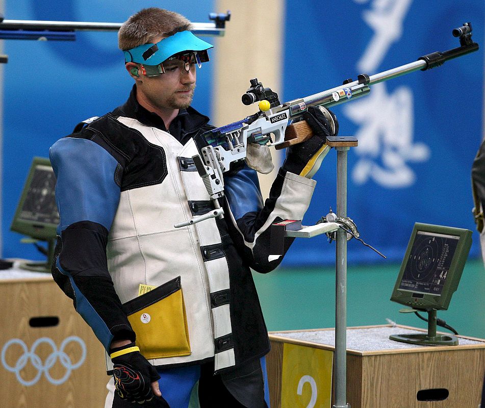 El estadounidense Matthew Emmons se prepara para disparar durante la final de 50 metros rifle 3x4 en la galería de tiro de Pekín.