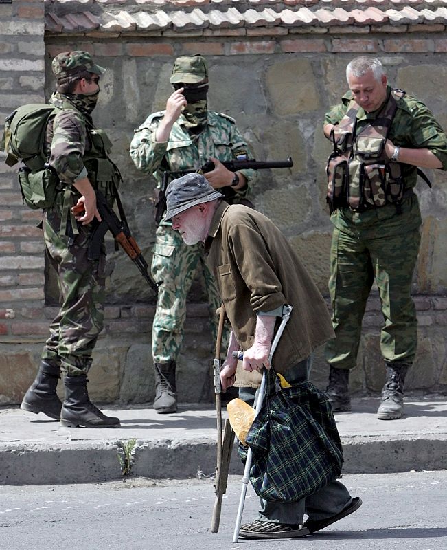 Un anciano camina cerca de unos soldados rusos en la ciudad de Gori, Georgia, el domingo 17 de agosto.