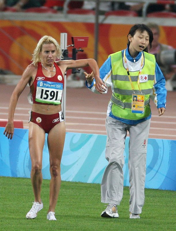 Marta Dominguez decide irse caminando sola hasta la zona de llegada a pesar de la ayuda ofrecida por un miembro de los servicios sanitarios.