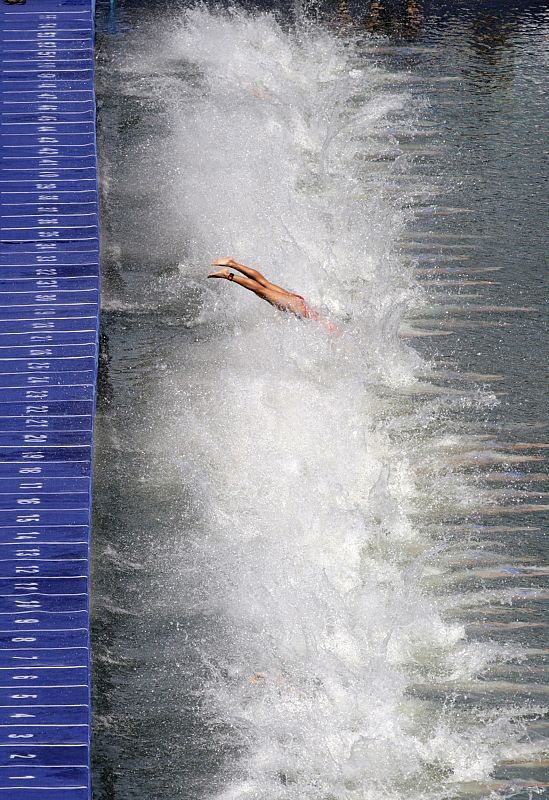 Una competidora del triatlón salta al agua del Ming Tomb.