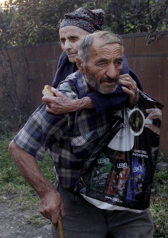 Una pareja de ancianos huye de las llamas que devoran su casa en Kvemo-Achebeti (Osetia del Sur)