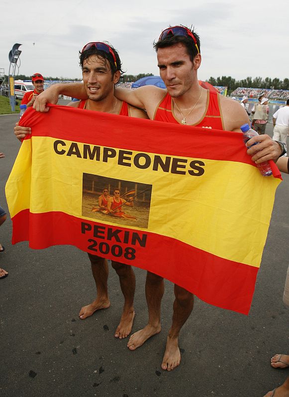 First placed Craviotto and Perez of Spain hold a flag with words 'Champions. Beijing 2008' as they pose after the kayak double (K2) 500m men final at the Beijing 2008 Olympic Games