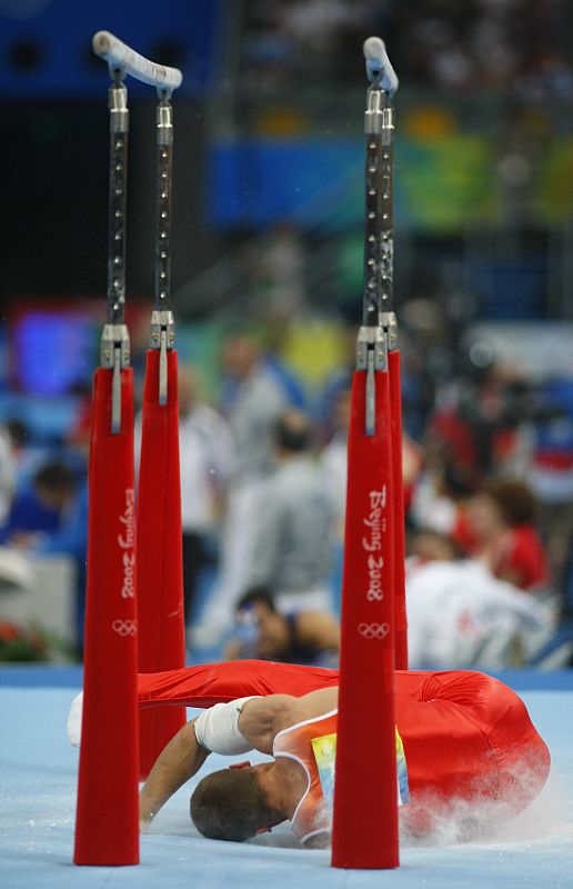 Dmitry Savitski of Belarus falls off the parallel bars during the men's individual all-around artistic gymnastics final at the Beijing 2008 Olympic Games