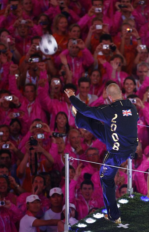 Soccer player David Beckham kicks a soccer ball during the closing ceremony of the Beijing 2008 Olympic Games at the National Stadium