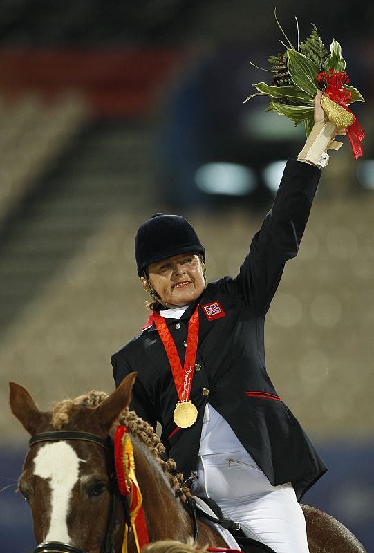 La británica Anne Dunham, de 59 años, celebra la medalla de oro en la competición ecuestre.