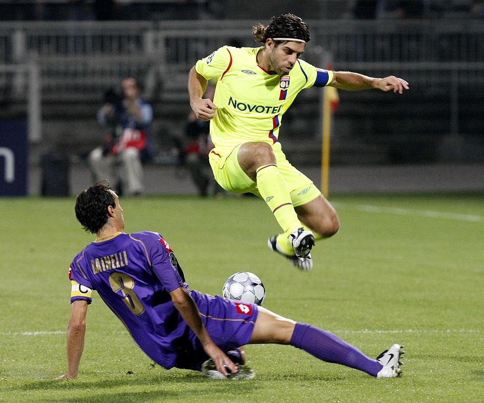 Juninho del Olympique de Lyon supera a Dainelli de la Fiorentina.