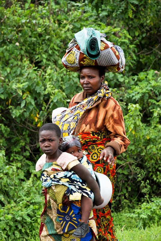 A woman and two children walk along the main road to Goma after fleeing fighting in Kibumba