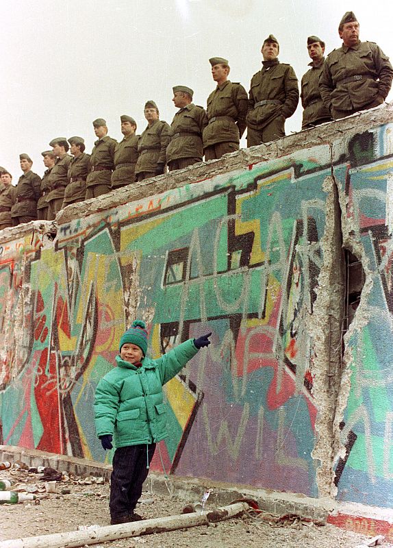 Una niña señala un agujero en el Muro de Berlín dos días después de su caída.N THIS FILE PHOTO.