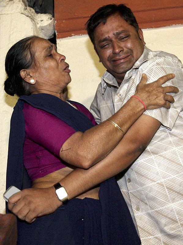 People grieve after a series of attacks in Mumbai