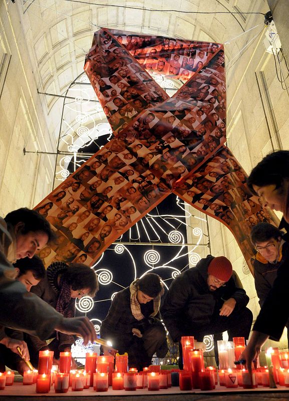 Un gran lazo rojo diseñado por los fotógrafos Juan Antino y Juan Alkamel recuerda a las víctimas del sida en la Puerta de Alcalá.