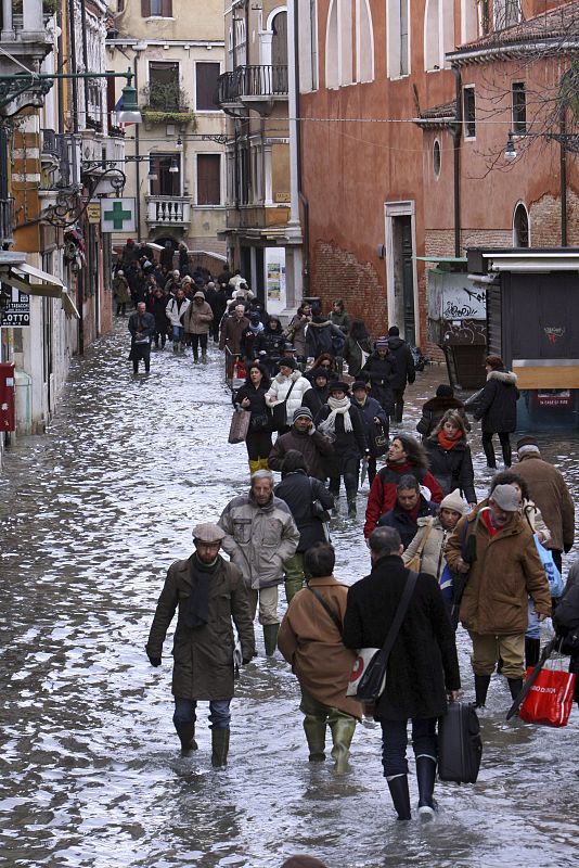 Los peatones caminan por las calles inundadas de Venecia