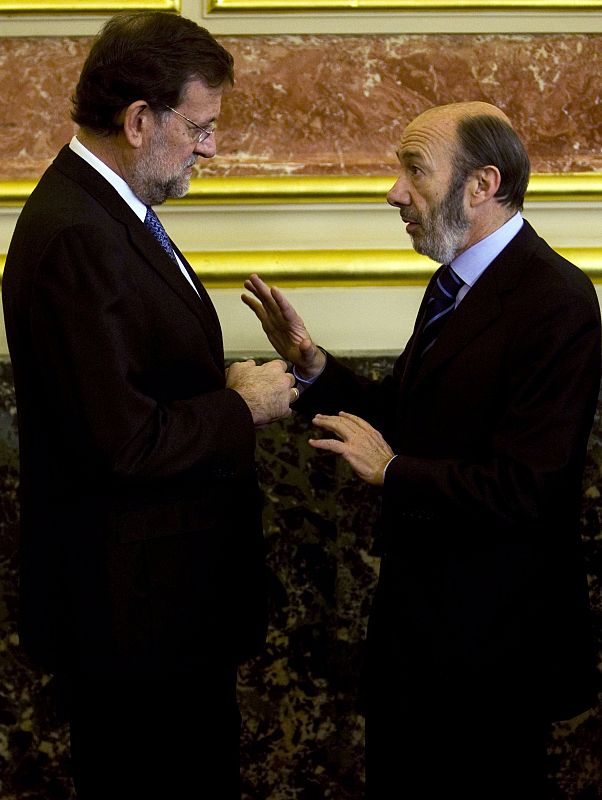 Spain's Interior Minister Perez Rubalcaba talks with main opposition leader Rajoy before a ceremony in Madrid