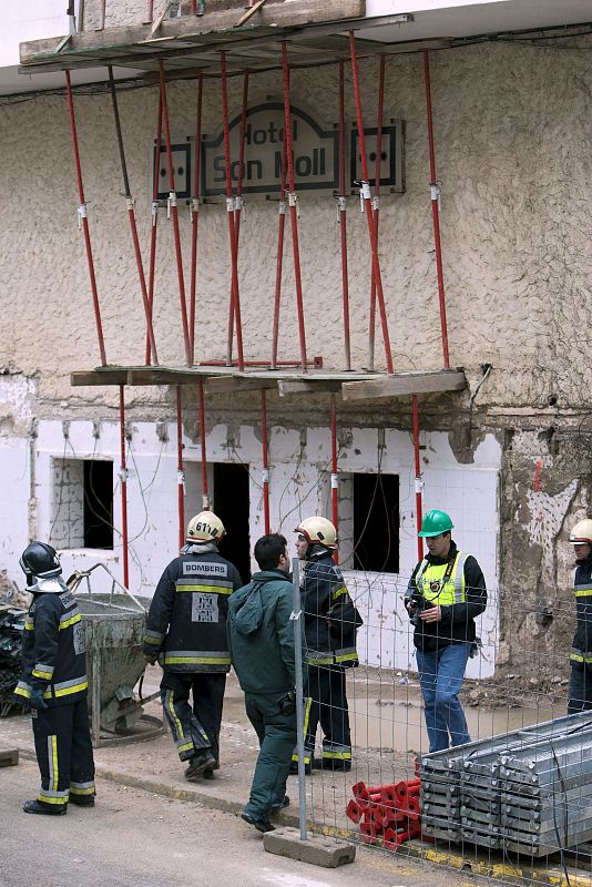 Miembros de los Bomberos de Mallorca y de la Guardia Civil, ante la fachada del hotel