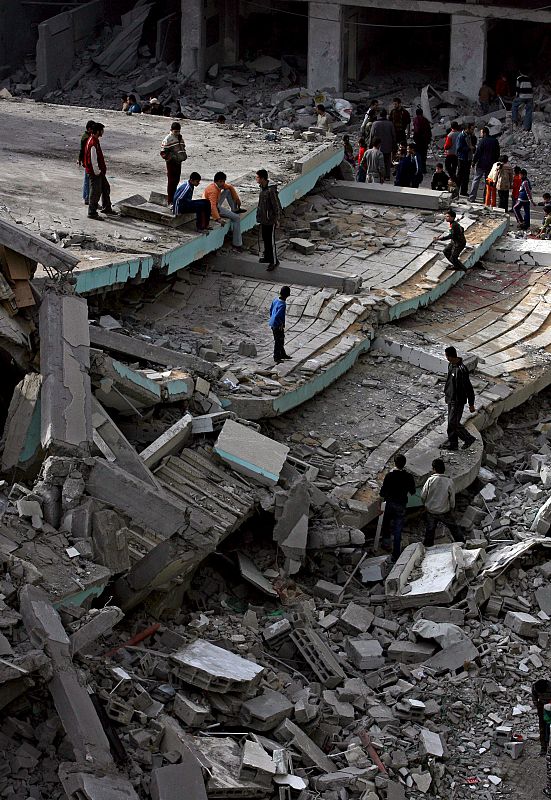 Varias personas observan los restos de la mezquita Hoda, destruida por misiles israelíes.