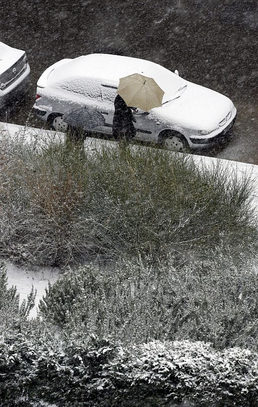 Un hombre se guarece de la intensa nevada  en la capital.