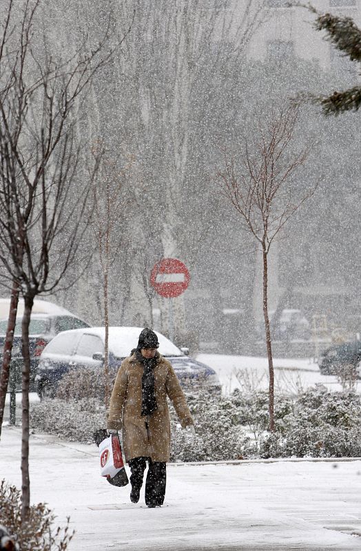 Una mujer camina sobre la nieve que ha causado importantes problemas circulatorios en la capital.